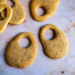 Plusieurs kaaks libanais dorés, saupoudrés de graines de sésame, sont disposés sur une surface claire.