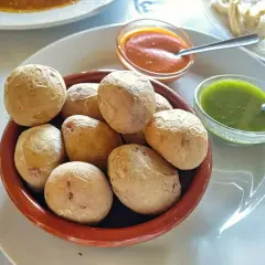 Pommes de terre canariennes salées servies avec une sauce mojo verde et une sauce rouge.
