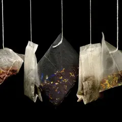 Cinq sachets de thé suspendus, révélant des mélanges variés de marc de thé et de fleurs séchées.