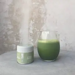 Boîte de matcha Tsuki et un verre de boisson verte. La quantité de matcha par tasse est parfaite pour un moment de détente.