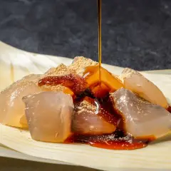 Glace translucide saupoudrée de poudre de soja grillé, nappée de sirop brun. Un délice de warabi mochi.