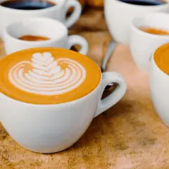 Tasses de café au lait avec une belle latte composition, sur fond de bois.