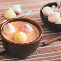 Chocolat chaud au lait d'amande, garni de meringues colorées. Un délice réconfortant.