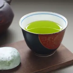 Une tasse de thé sencha bienfaits, avec une touche de mochi vert et une théière japonaise.