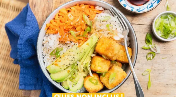 Bol coloré avec riz, carottes râpées, avocat et cubes de tofu teriyaki croustillants, garni de ciboule.
