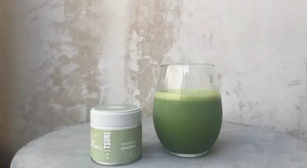 Boîte de matcha Tsuki et un verre de boisson verte. La quantité de matcha par tasse est parfaite pour un moment de détente.