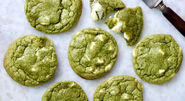 Des cookies clairs au matcha, parsemés de morceaux de chocolat blanc, prêts à être dégustés. Un délice vert et blanc.