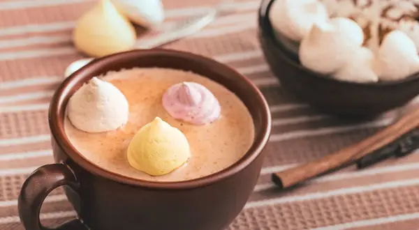 Chocolat chaud au lait d'amande, garni de meringues colorées. Un délice réconfortant.
