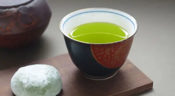 Une tasse de thé sencha bienfaits, avec une touche de mochi vert et une théière japonaise.