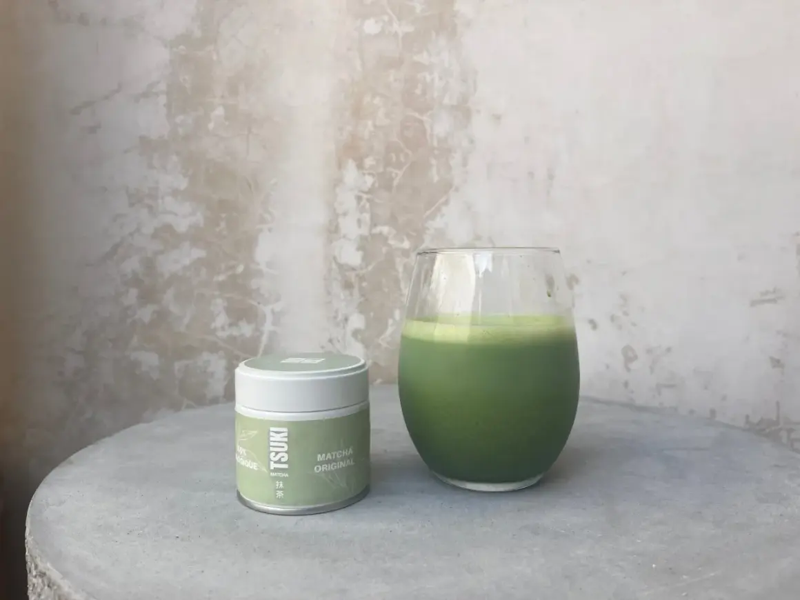 Boîte de matcha Tsuki et un verre de boisson verte. La quantité de matcha par tasse est parfaite pour un moment de détente.