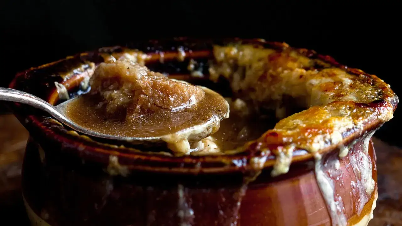 Cuill&egrave;re de soupe &agrave; l'oignon gratin&eacute;e, avec des morceaux d'oignon fondus et un fromage dor&eacute;. Un d&eacute;lice r&eacute;confortant, parfum&eacute; comme un clou de girofle.