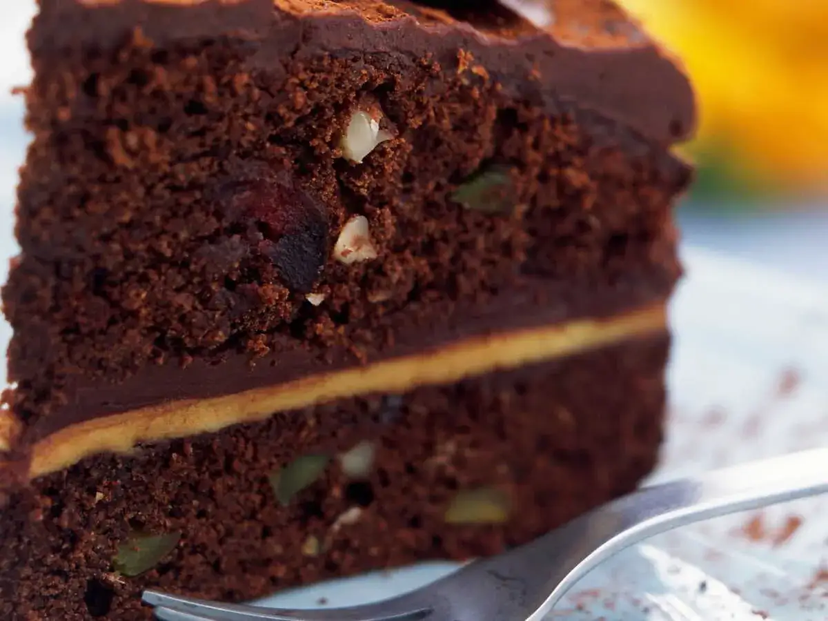 Tranche de g&acirc;teau au chocolat noir, garnie de fruits secs et de noix. Une d&eacute;licieuse recette de black cake.