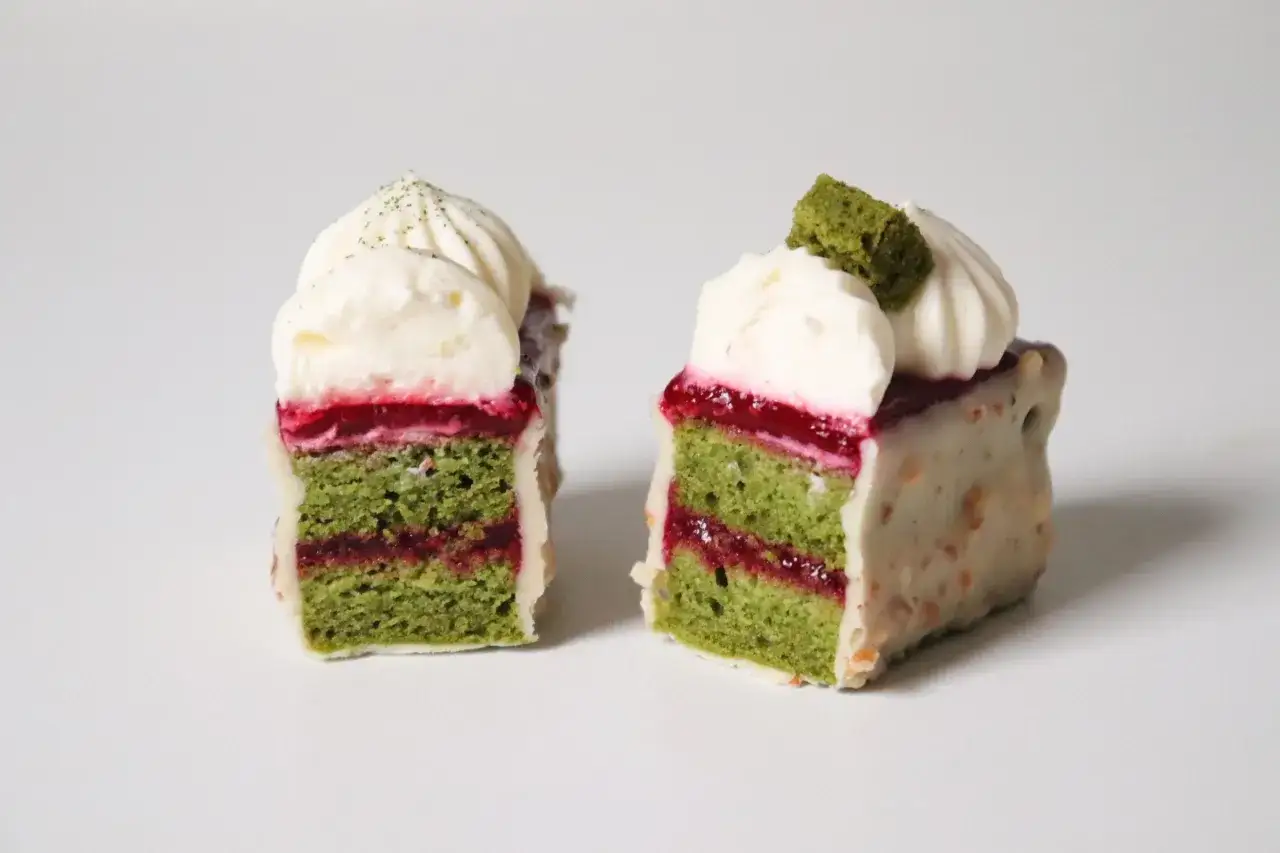 Deux petits g&acirc;teaux aux couches vertes de matcha, garniture rouge et cr&egrave;me fouett&eacute;e. Un d&eacute;lice visuel et gustatif, avec une touche de ganache matcha.