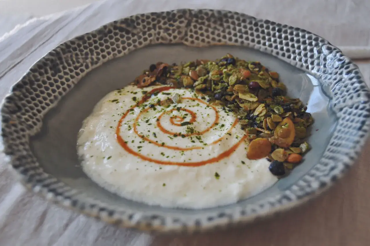 Houmous claire au matcha, garni de granola et d'un filet de sauce. Un d&eacute;lice visuel et gustatif.