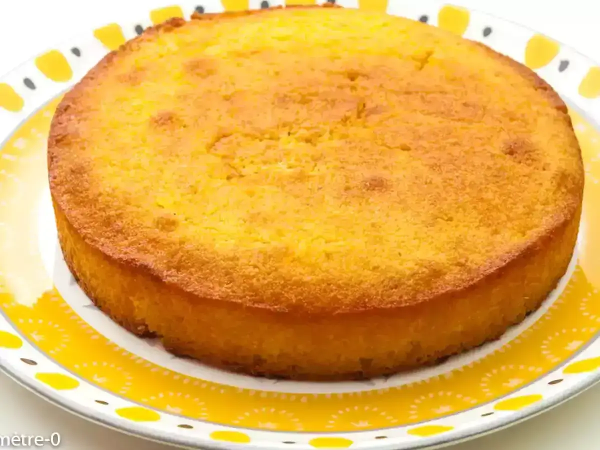 Un d&eacute;licieux g&acirc;teau arabe orange, dor&eacute; et moelleux, pos&eacute; sur une assiette aux motifs jaunes.