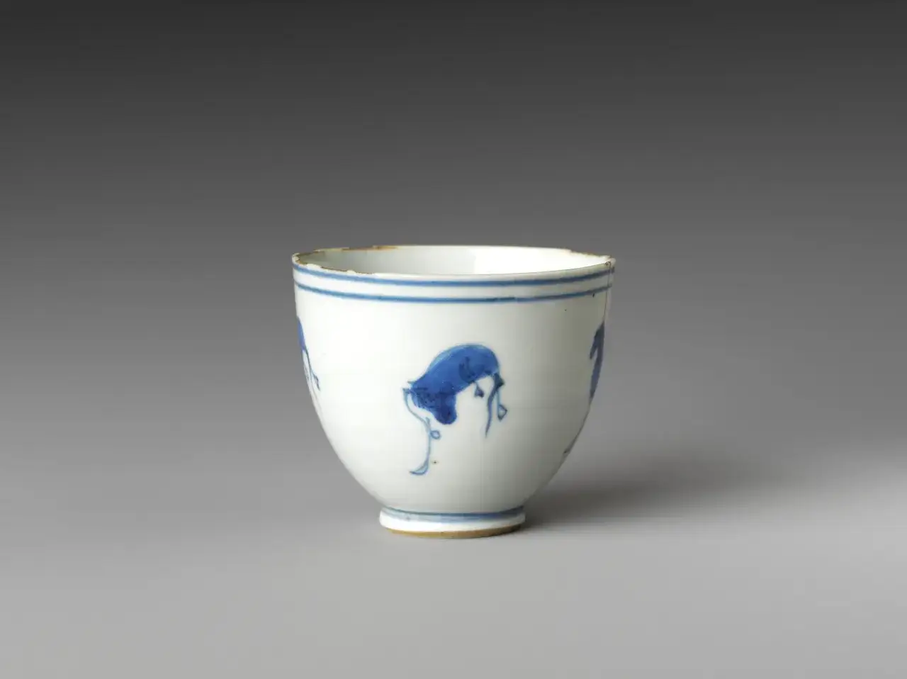 Tasse en porcelaine blanche ornée de motifs bleus, évoquant l'histoire du thé et ses traditions ancestrales.