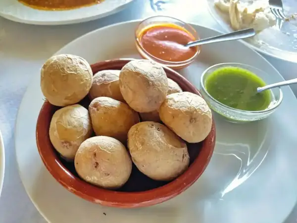 Pommes de terre canariennes salées servies avec une sauce mojo verde et une sauce rouge.