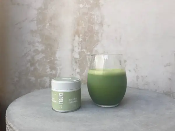 Boîte de matcha Tsuki et un verre de boisson verte. La quantité de matcha par tasse est parfaite pour un moment de détente.