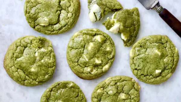 Des cookies clairs au matcha, parsemés de morceaux de chocolat blanc, prêts à être dégustés. Un délice vert et blanc.