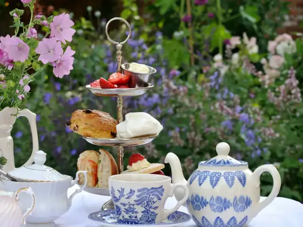 Un délicieux tea time en plein air avec scones, fraises et thé. Un moment de détente au jardin.